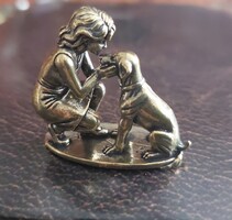Miniatűr sárgaréz kutyát ölelő lány