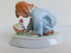 Kézi festésű, hibátlan állapotú Zsolnay porcelán búgócsigával játszó kislány figura
