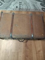 Békebeli, fémlecekkel és szegecsekkel erősített vintage bőrönd (vagy utazóláda) látható a 20. száza