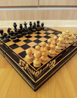 Vintage wooden chess set with carved pieces and foldable board