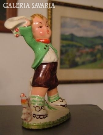 Old ceramic figure. Waving boy.