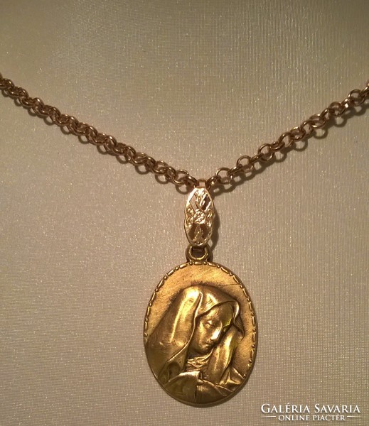Gold colored Mary pendant on a gold colored chain.