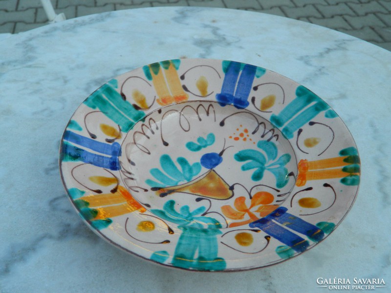 Wall-mounted earthenware plate with a folk bird pattern