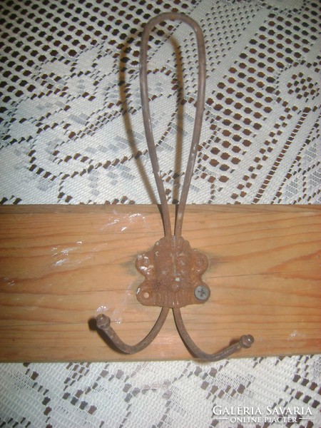 Old metal-wooden wall hanger with convex head motifs