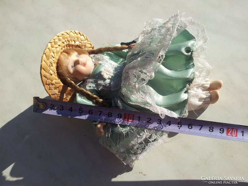 Porcelain head doll in green silk dress