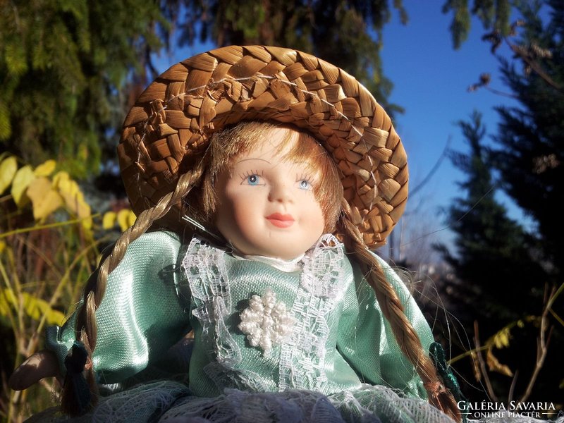 Porcelain head doll in green silk dress