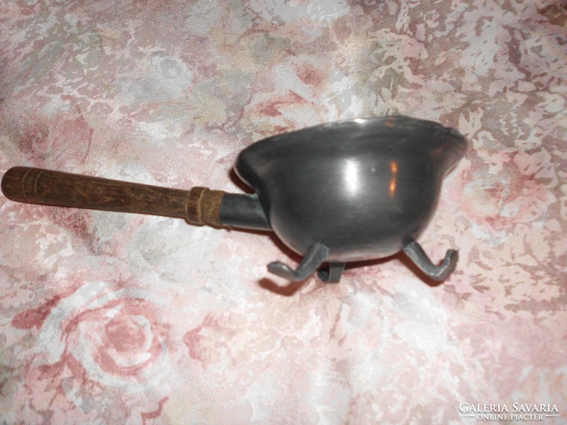 3 A marked vessel with a handle standing on clawed feet.