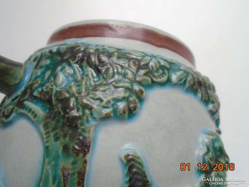 Decorative hunter's cup with raised tree, flower and animal patterns with green tones