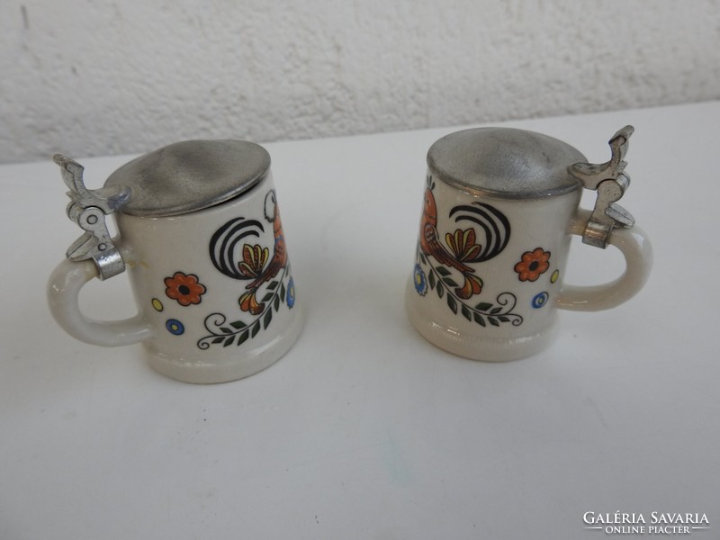 A pair of mini cups with tin lids with a pattern of a couple of love birds