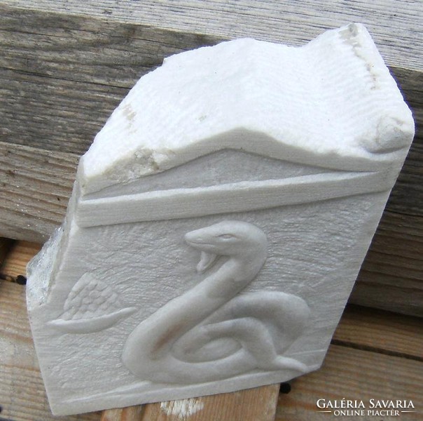 Stone carving relief of Greek snake demon from Carrara marble