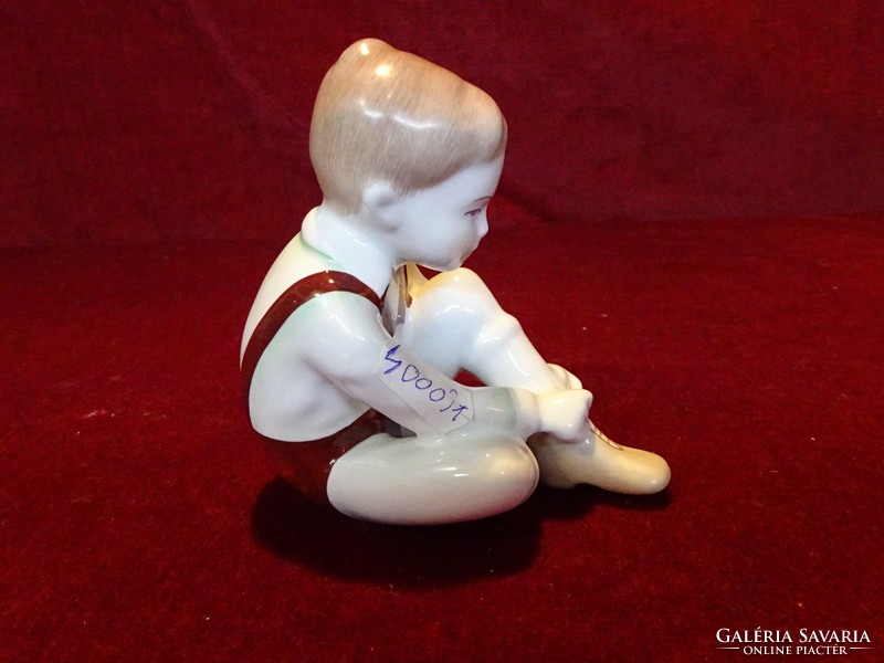 Aquincum porcelain figural statue, little boy tying shoes. 11 cm high, 10 cm wide. He has!