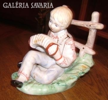 Hand-painted old porcelain: boy playing harmonica