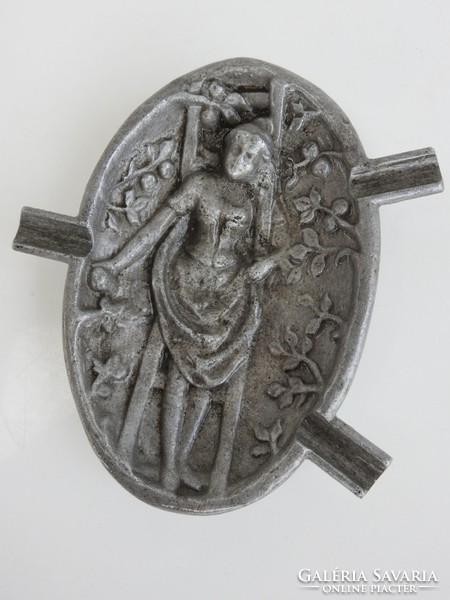 An old, plastically bulging ashtray made of aluminum: a woman picking fruit