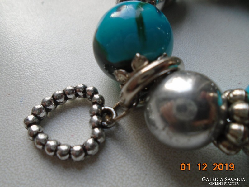 Silver-plated flower in a socket, bracelet with pendants made of green and silver beads