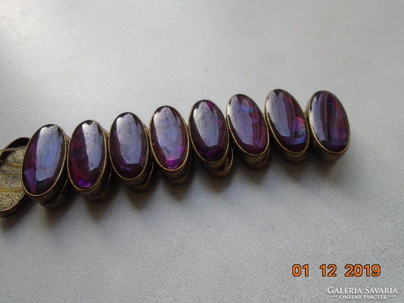 Tűzaranyozott bronz ovális foglalatban színjátszó lila zománc szemekből karkötő