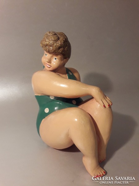 Vintage statue of a woman in a bathing suit sunbathing on the beach