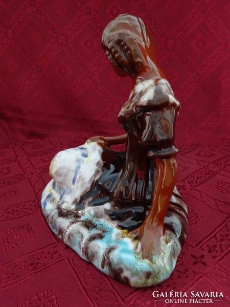 Porcelain figural sculpture, hand painting, of a lady sitting on the grass with a hat in her hand. He has!