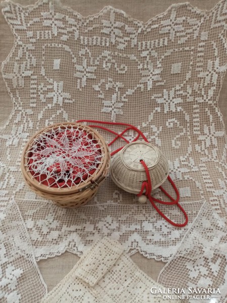 Old lace tablecloth with crochet hooks in a log with a ball in a small wicker basket with supplies
