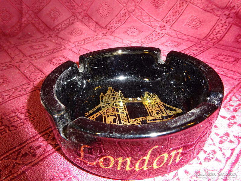 Black glass ashtray with tower bridge skyline and London inscription. He has!