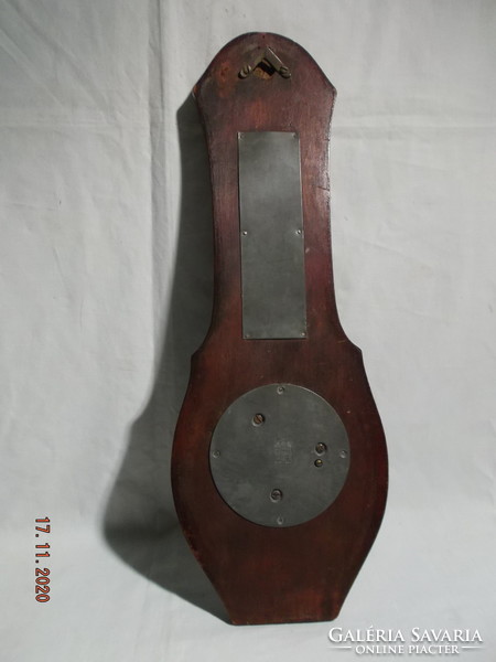 Old thermometer and barometer in a wooden case that can be hung on a wall.