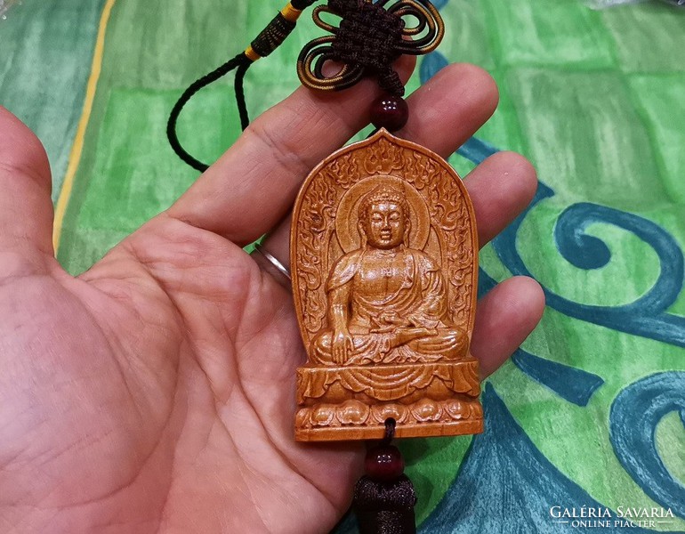Real room. Rosewood pendant, amulet, meditating Shakyamuni Buddha
