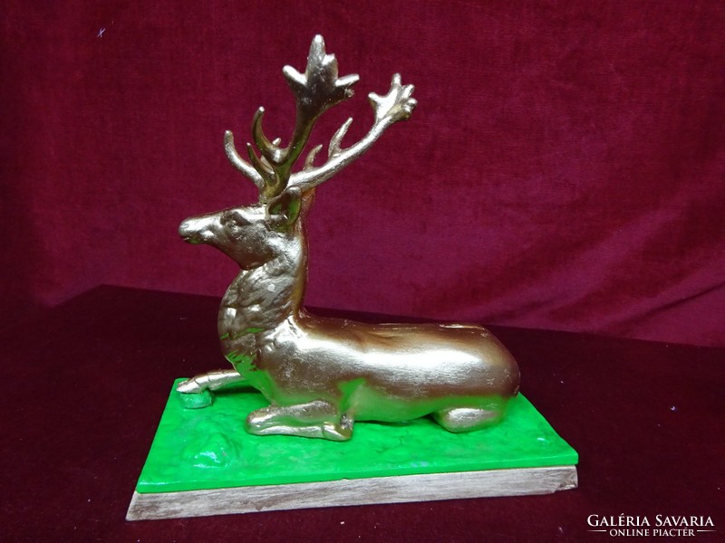 Cast reindeer on a wooden background. He has a gilded painting. He has!