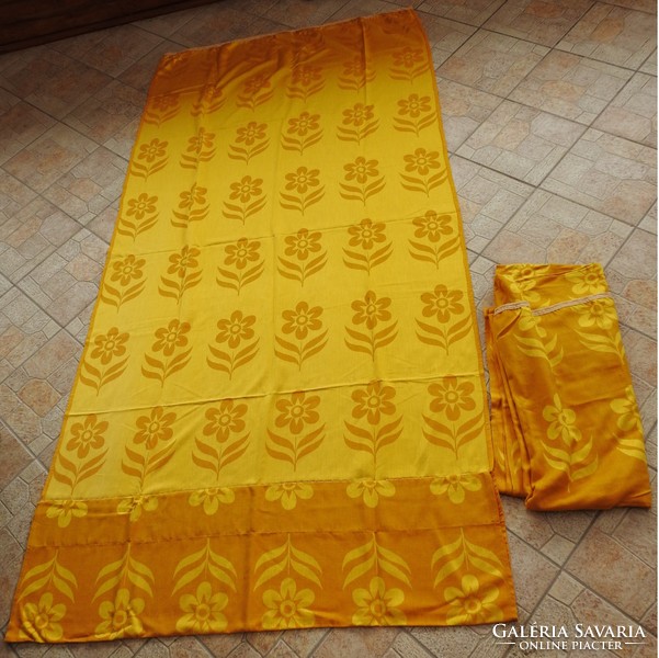 A pair of blackout curtains with a golden flower pattern