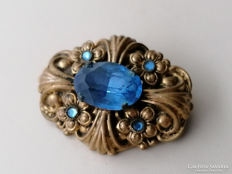 Old brooch badge decorated with blue stones