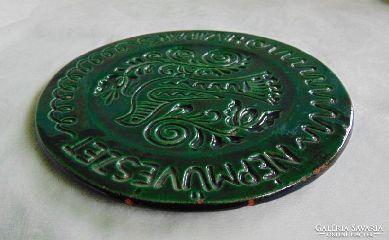 Old green glazed wall plate with folk art - cottage industry inscription, wall decoration