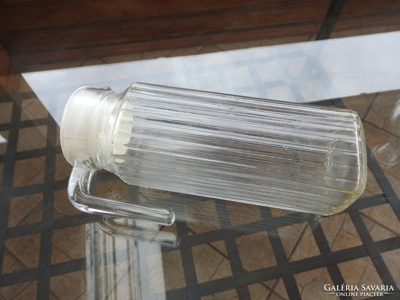 Old ribbed glass jug with plastic stopper