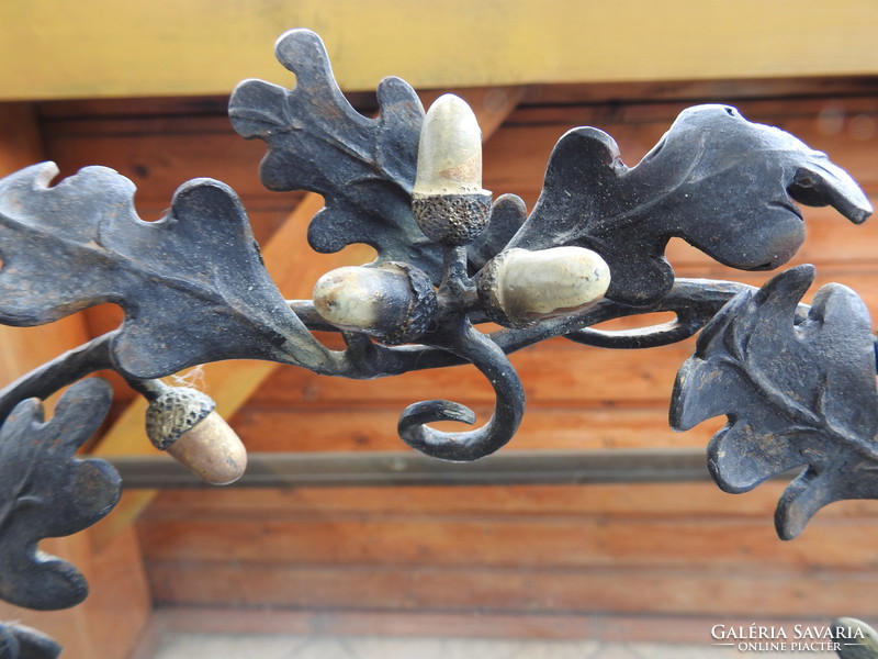 Antique wrought iron three-pronged candle holder with acorn decoration