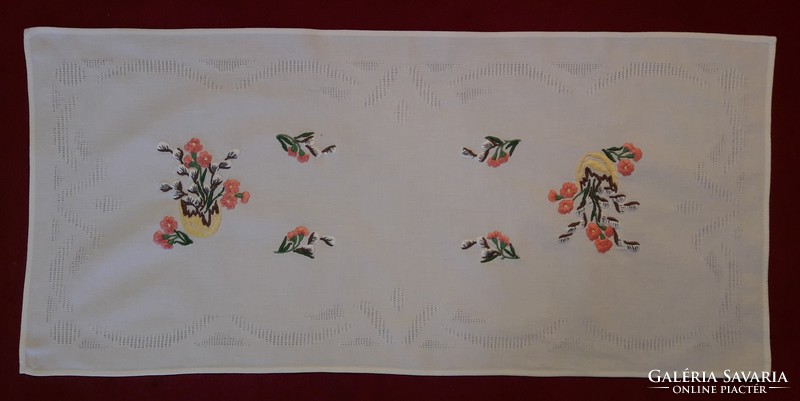 Embroidered runner with perforated frame.