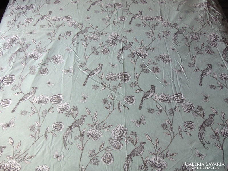Quilt cover with bird and flower motif on a light pastel green background