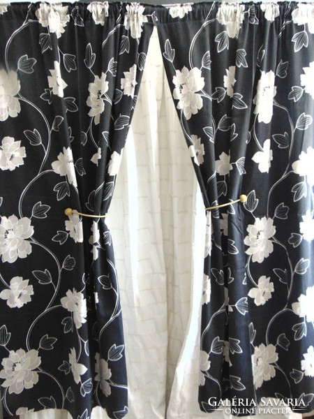 Beige flower patterned curtains on a black background