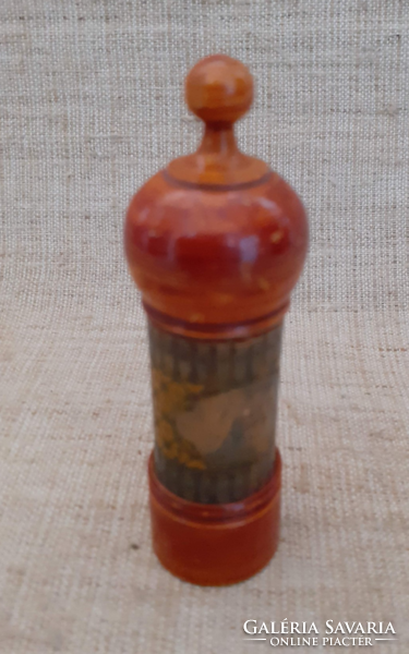 A polished glass jar with perfume essence in an antique wooden jar.