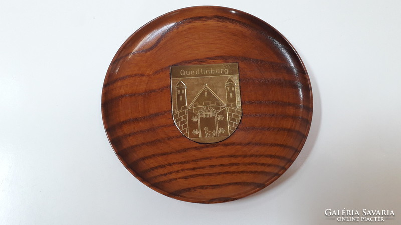 Small wooden bowl with copper coat of arms hanging on the wall