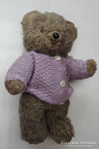 Old teddy bear in a cardigan