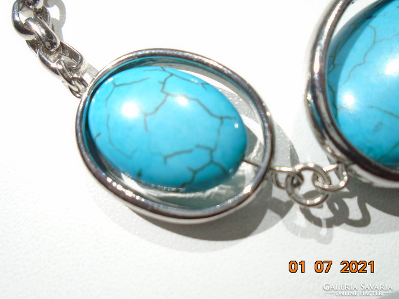 3 large polished bracelets with a turquoise stone that can be rotated on the axis, enclosed in a silver-plated frame