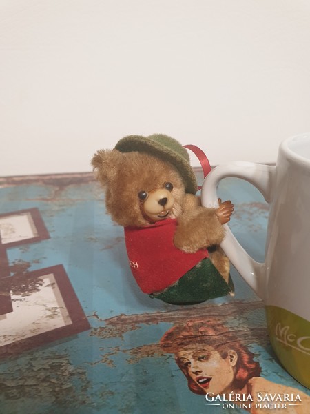 Old clipped teddy bear in Mr. green hat