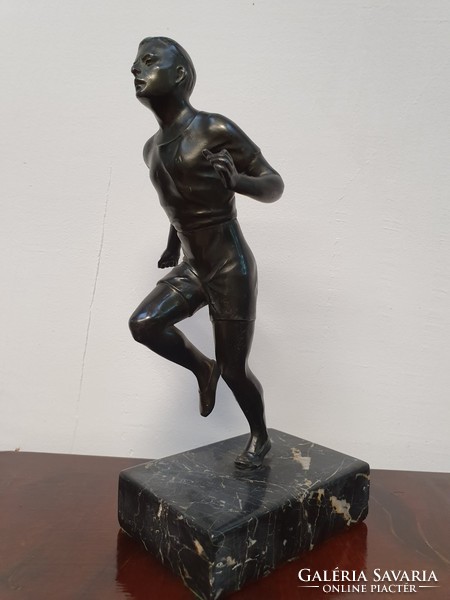 Running man with bronze statue on marble base