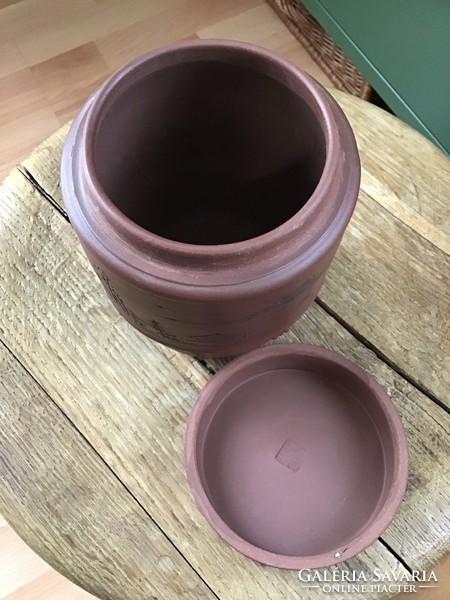 Old oriental terracotta pot with lid