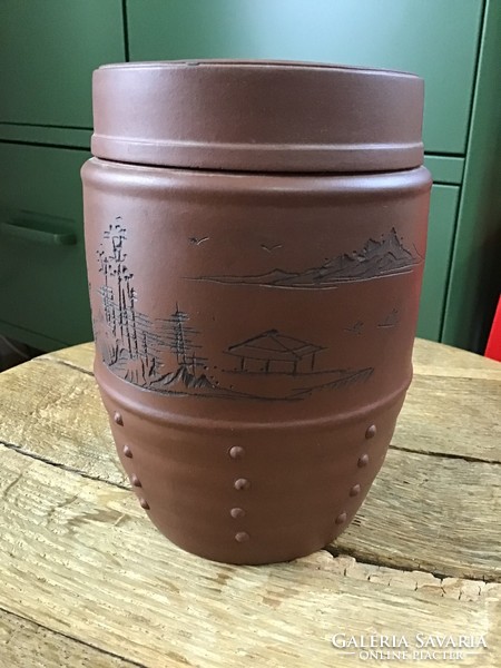 Old oriental terracotta pot with lid