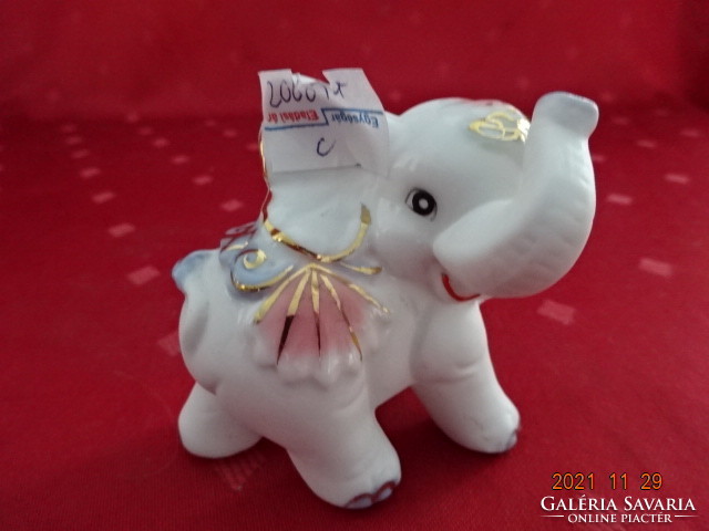 German porcelain elephant in a colorful dress on a matte background. He has!