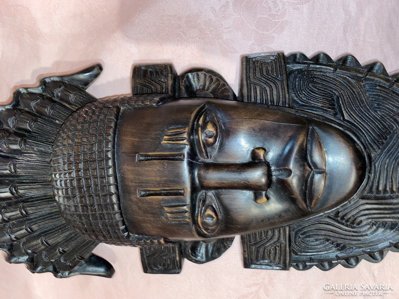 Fantastic African carved wood warrior head with rich mask-like detail on the wall.