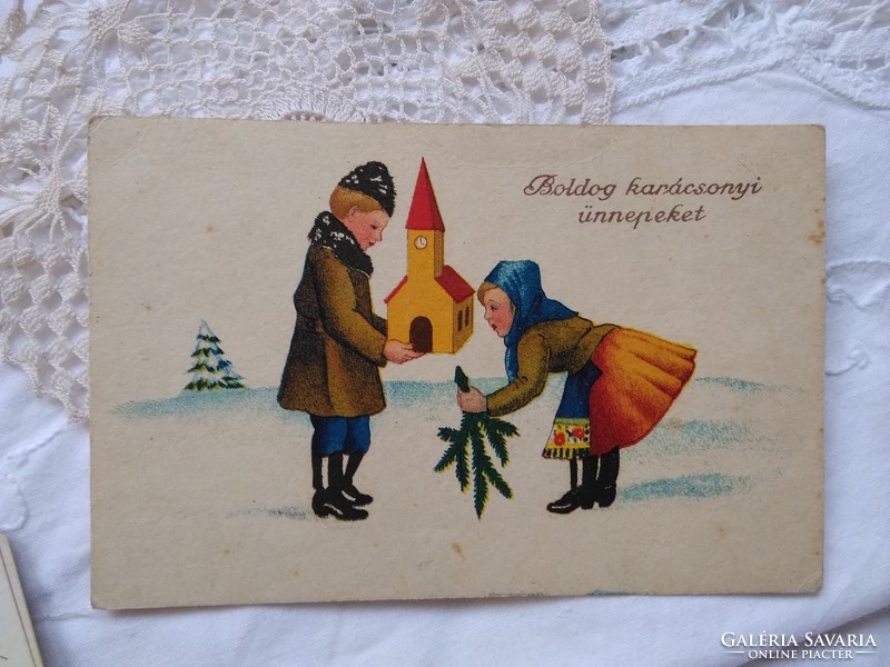 Old graphic, Christmas postcard / greeting card with couple in traditional costume, church, pine branch circa 1930