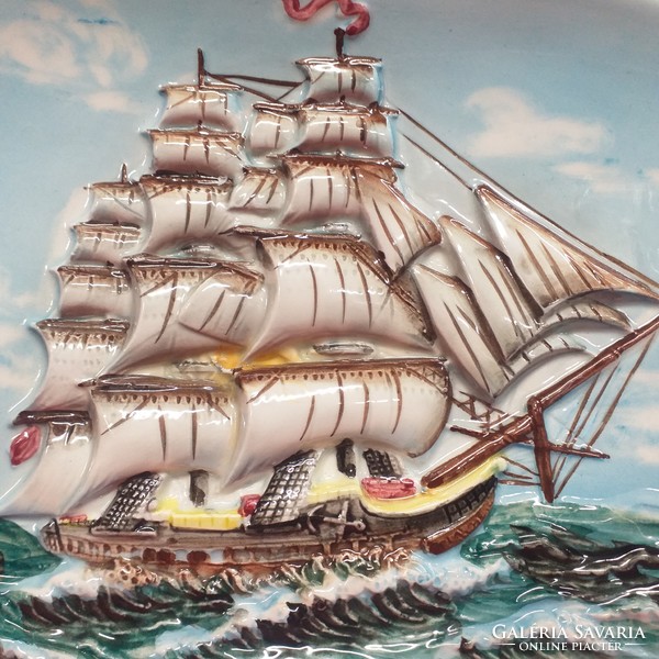 A sailing ship with a relief pattern on the sea, wall ceramics.