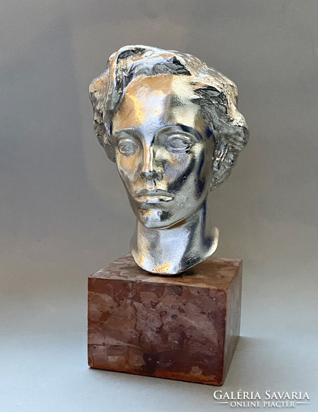 Old silver-plated female head on a marble base.
