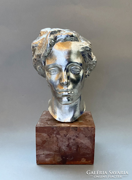 Old silver-plated female head on a marble base.