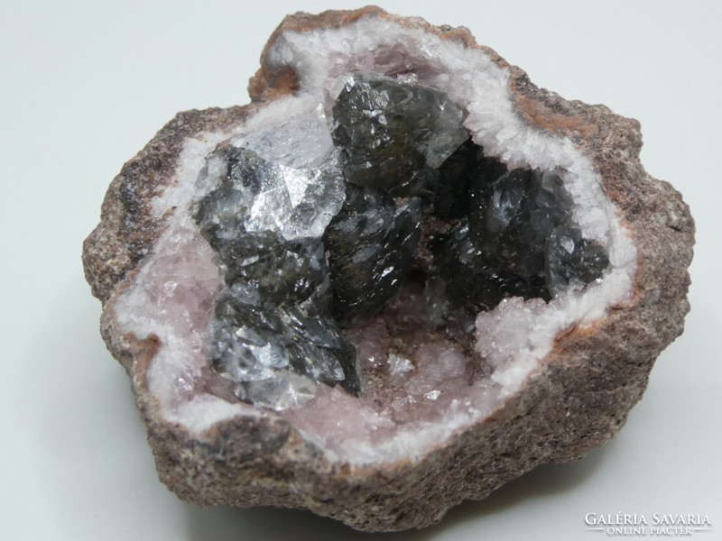 Natural pink quartz and gray calcite crystals in the geode. Fluorescent mineral specialty
