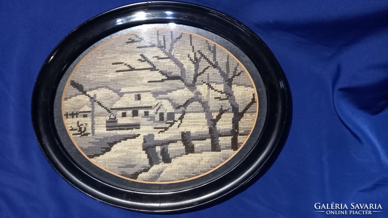 Winter landscape depicting goblein in an oval black frame